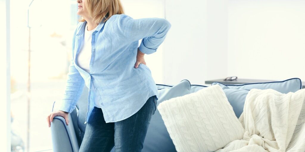 Senior woman suffering from backache at home
